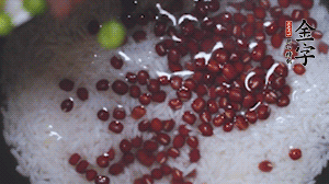 將炒好的食材和大米、紅豆一起放進(jìn)電飯鍋煮。