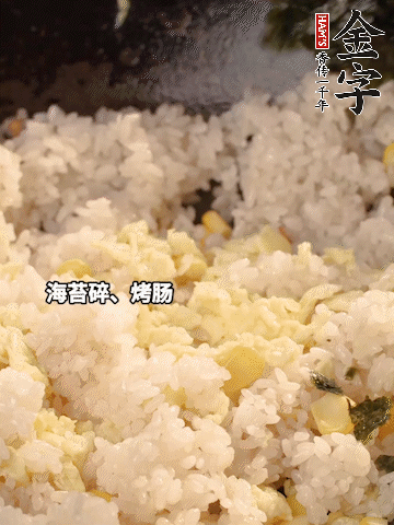 剩米飯下鍋炒散，依次下玉米粒、雞蛋、烤腸、海苔碎翻炒均勻。