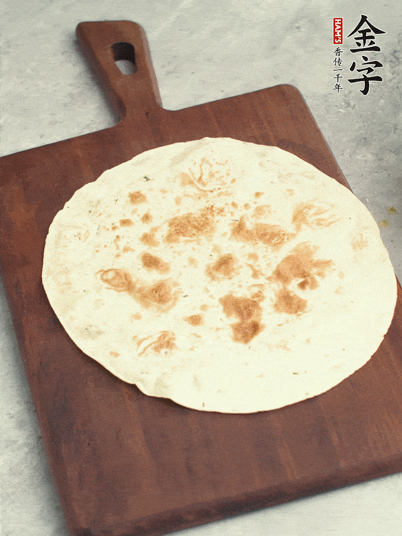 食材依次鋪在卷餅皮上，卷起來(lái)。