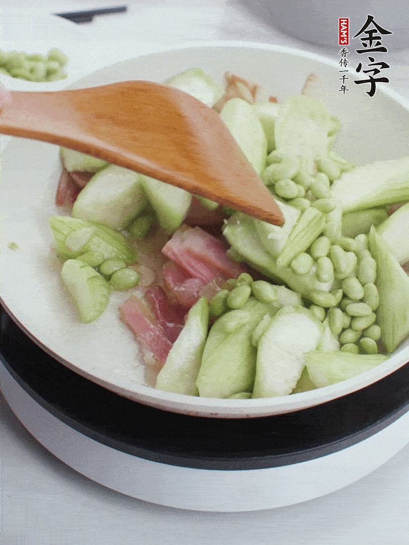 依次下絲瓜、青豆翻炒，炒至絲瓜打蔫縮小。