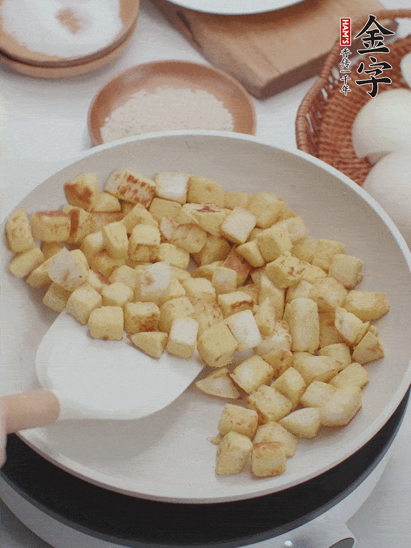 起鍋熱油，倒入饅頭丁，小火煎至蛋液凝固定型再翻面，饅頭丁部煎至金黃時盛起待用。