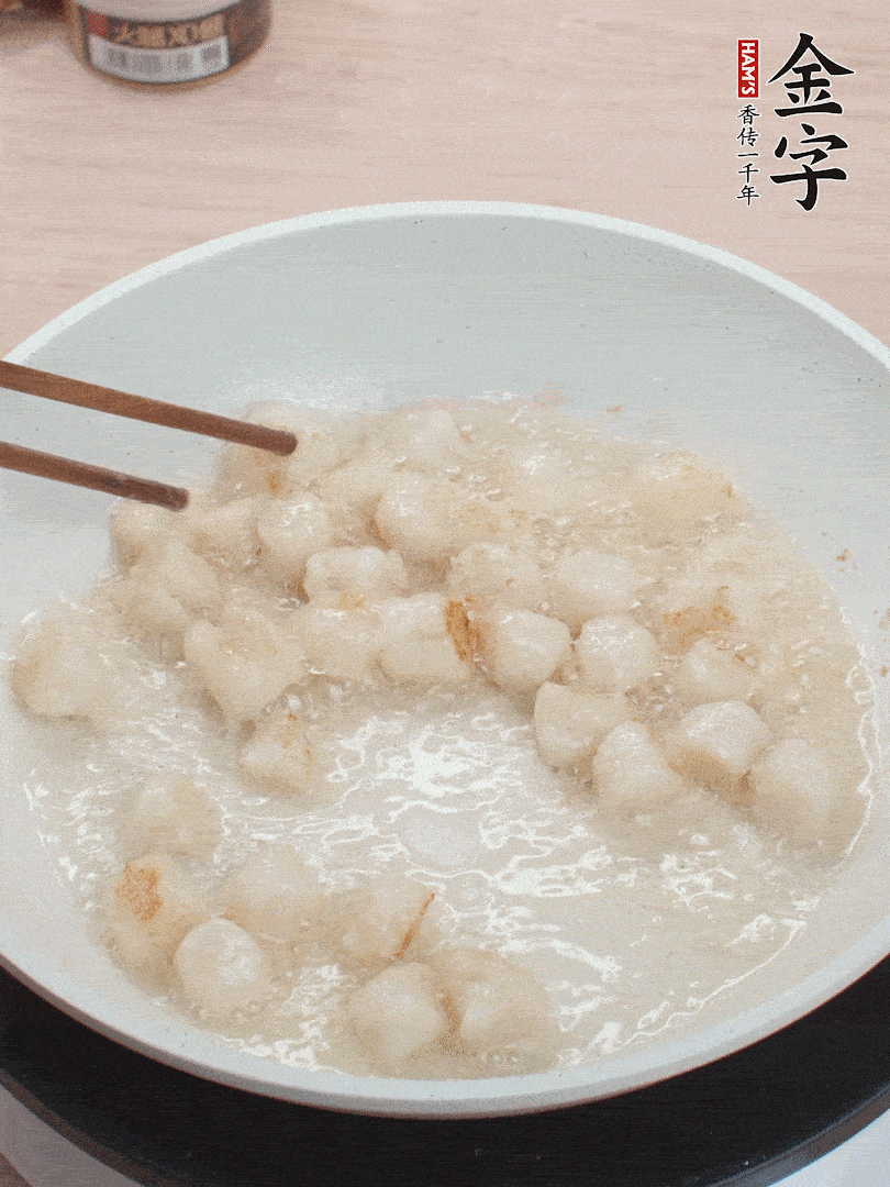 油溫4成熱，鮮貝蘸干淀粉下鍋煎，一面微黃后翻面。