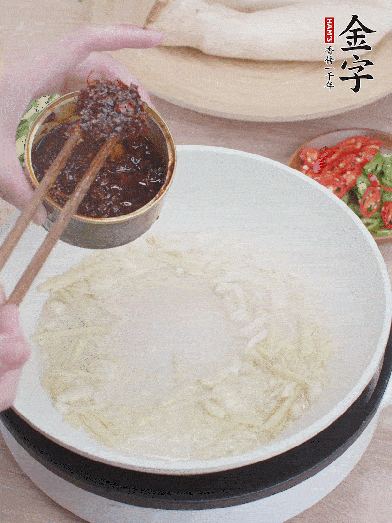 起鍋熱油，姜蒜、金字火腿干貝醬煸香。