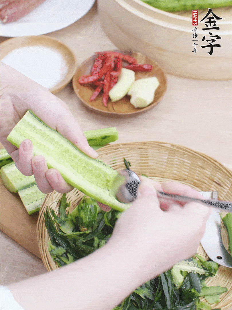 黃瓜削皮，對(duì)半切開(kāi)，勺子挖去內(nèi)瓤，斜刀切片。青蒜斜刀切段。