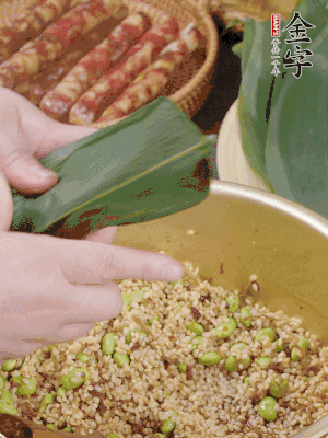 粽葉往下折，完全蓋住，兩側(cè)捏緊。
