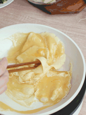 油6成熱時(shí)，下雞蛋液，邊緣凝固時(shí)翻拌成塊狀。
