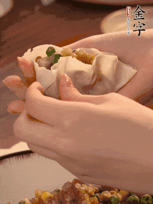 取一大勺餡料放進餃子皮里，用大拇指按住頂部餡料，再用虎口掐出形狀。