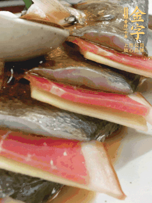 魚(yú)肚中塞蔥結(jié)、火腿片，魚(yú)身上碼放姜片、火腿片，倒入混合的料汁。