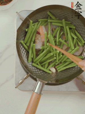 下掰好的缸豆段翻炒，略燜煮。