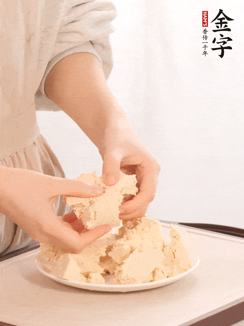 老豆腐用手掰成塊。