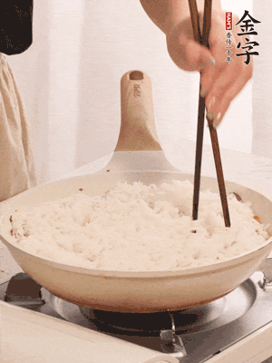 把瀝干水分的米飯均勻鋪在上面，筷子戳幾個洞，以便透氣，轉小火蓋上蓋子燜至水分收干，大概10分鐘。